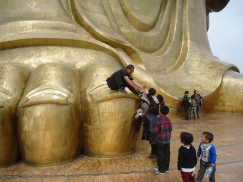 Туристы фотографируются на фоне статуи Будды